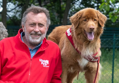 Un uomo e un cane in posa per una foto.