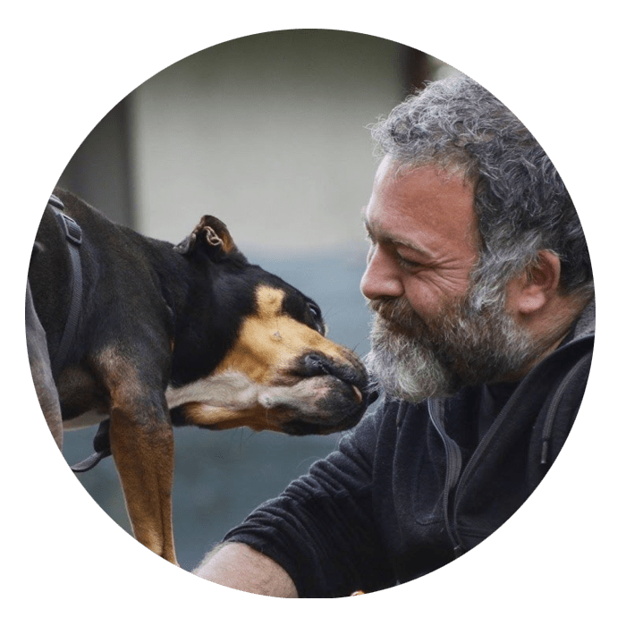 Un uomo che bacia un cane in cerchio.