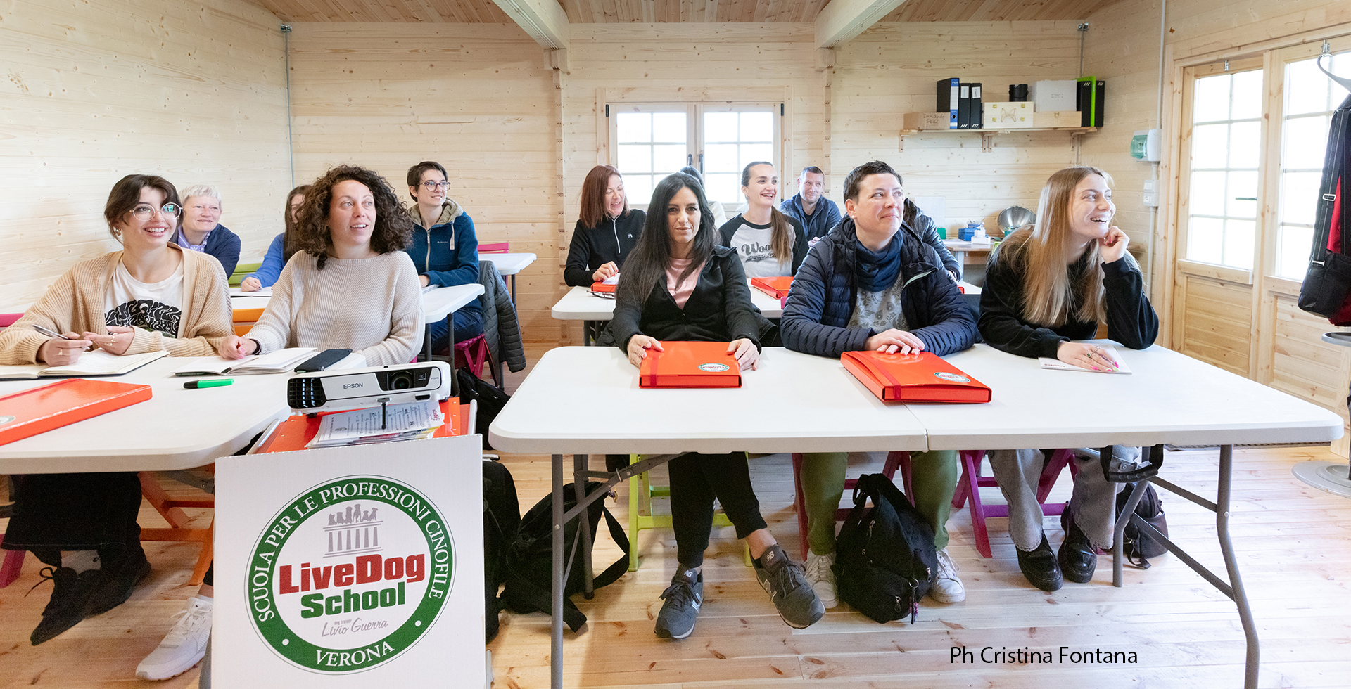 Un gruppo di persone sedute ai tavoli in un’aula.